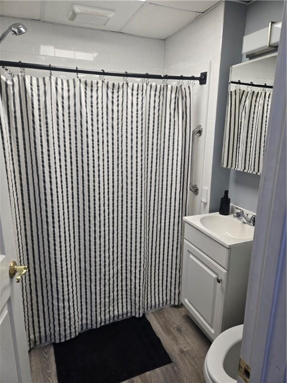 bathroom featuring vanity, walk in shower, hardwood / wood-style floors, and toilet