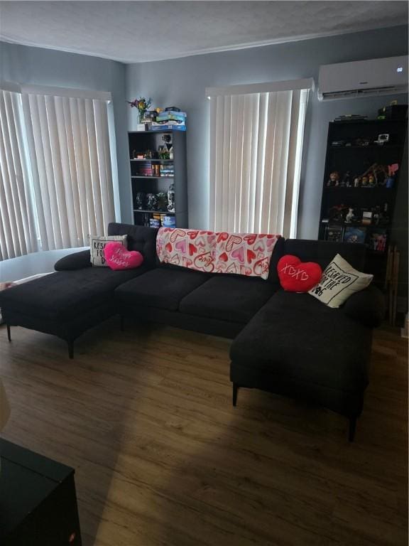 living room featuring an AC wall unit, plenty of natural light, and hardwood / wood-style flooring