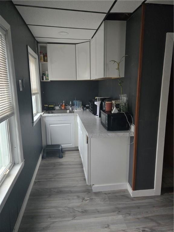 kitchen with sink, white cabinets, and light hardwood / wood-style floors