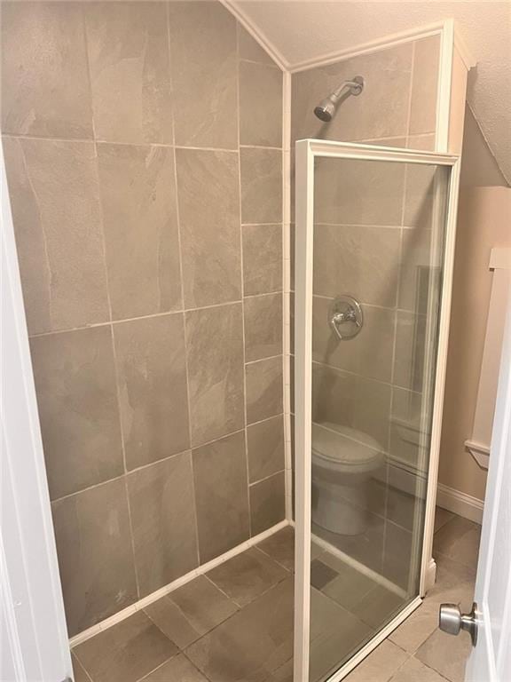 bathroom featuring tile patterned floors, walk in shower, and toilet