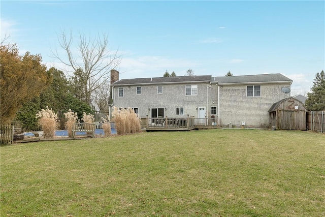 back of house featuring a wooden deck and a lawn