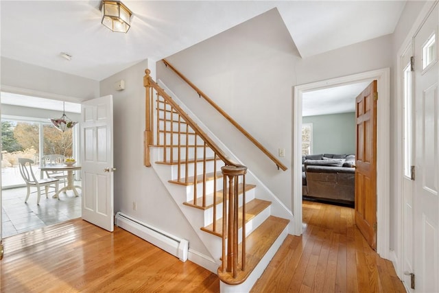 stairway featuring a baseboard radiator and hardwood / wood-style floors