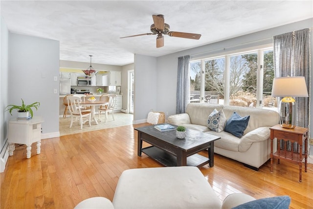 living room featuring ceiling fan and light wood-type flooring