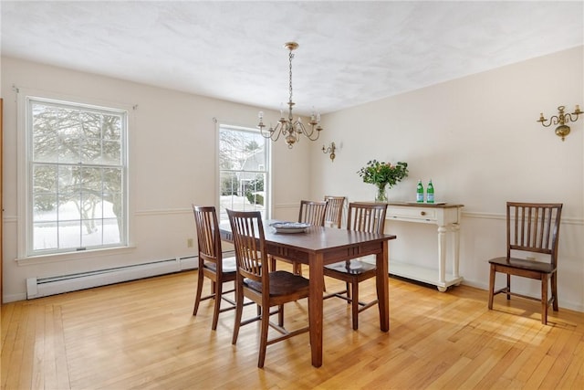 dining space featuring a baseboard radiator, a chandelier, and light hardwood / wood-style flooring