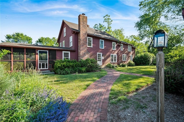 back of property featuring a sunroom and a yard