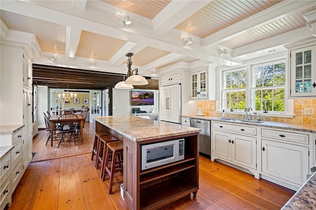 kitchen with sink, tasteful backsplash, a kitchen island, a breakfast bar area, and stainless steel appliances