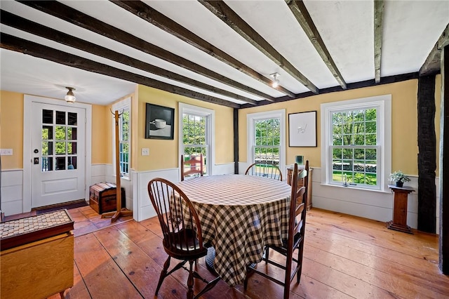 dining room featuring hardwood / wood-style flooring and beam ceiling