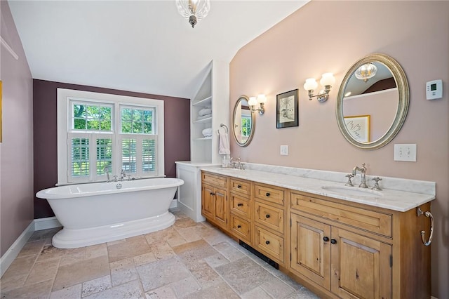 bathroom with vanity, a bathtub, and vaulted ceiling