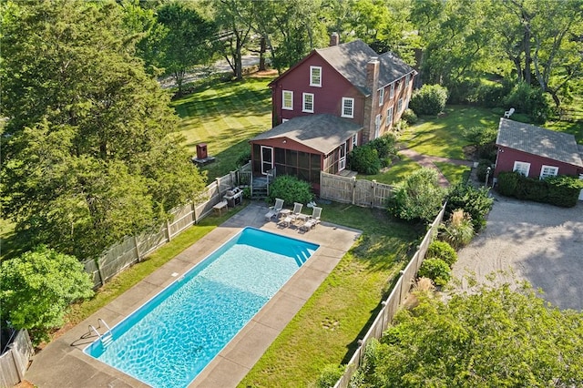 view of pool with a sunroom, a yard, and a patio