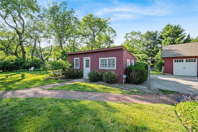 view of front of home featuring a front yard, an outdoor structure, and a garage