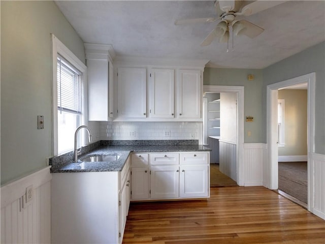 kitchen featuring ceiling fan, sink, white cabinetry, and light hardwood / wood-style flooring