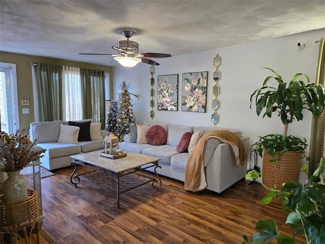 living room with ceiling fan, a textured ceiling, and dark hardwood / wood-style flooring