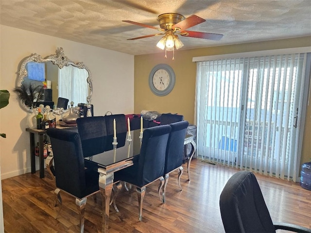 dining room featuring hardwood / wood-style flooring, a textured ceiling, and ceiling fan