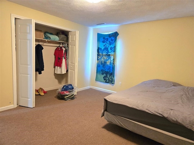 carpeted bedroom with a closet and a textured ceiling