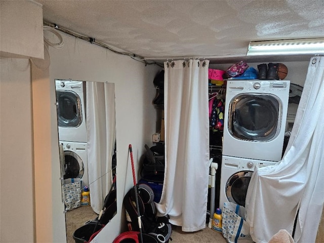 clothes washing area featuring stacked washer and clothes dryer, a textured ceiling, and carpet flooring