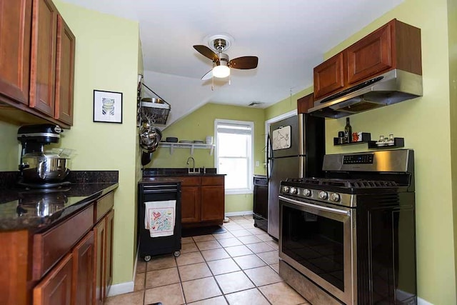 kitchen with ceiling fan, dishwashing machine, dark stone counters, light tile patterned flooring, and gas stove