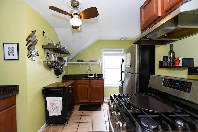 kitchen with appliances with stainless steel finishes, sink, light tile patterned floors, ventilation hood, and lofted ceiling