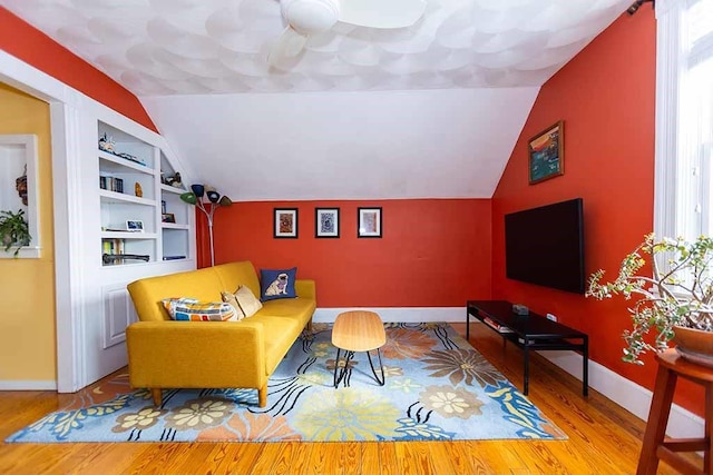 living room featuring built in shelves and hardwood / wood-style floors