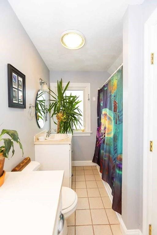 bathroom featuring toilet, tile patterned flooring, and vanity