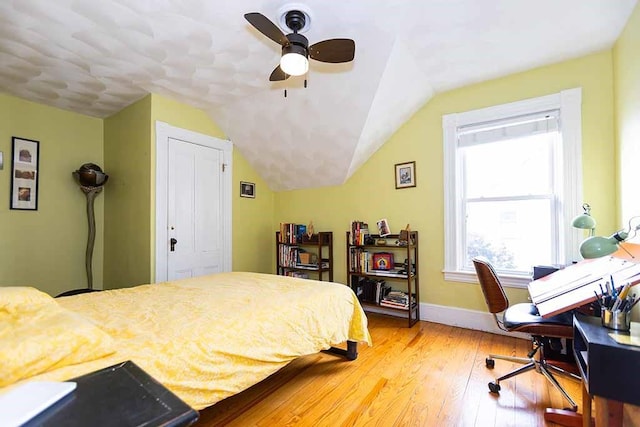 bedroom with ceiling fan, hardwood / wood-style flooring, and lofted ceiling