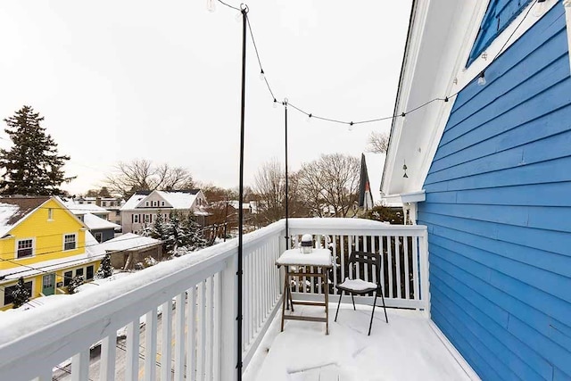 view of snow covered back of property