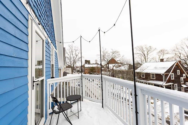 view of snow covered back of property