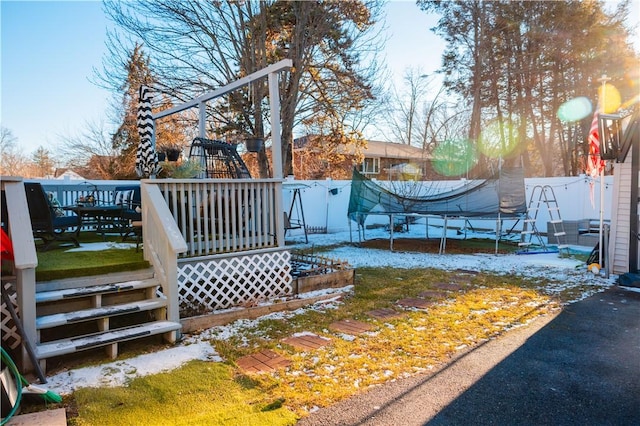 exterior space featuring a playground, a trampoline, and a wooden deck