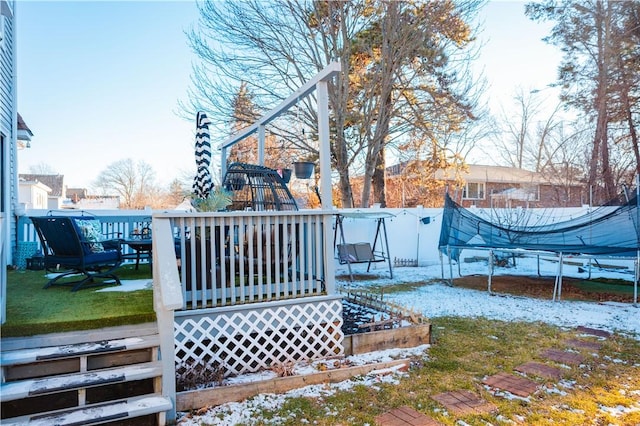 snow covered deck with a trampoline