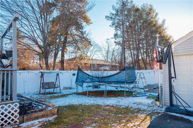 yard covered in snow with a trampoline