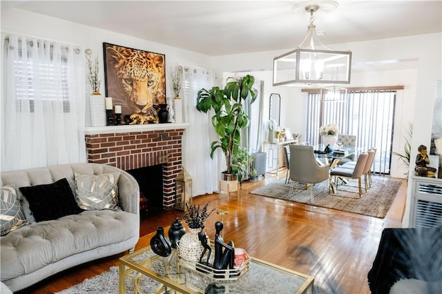 living room featuring a notable chandelier, hardwood / wood-style floors, and a fireplace