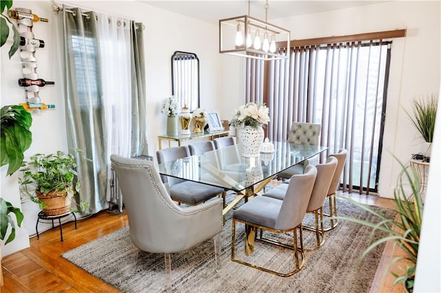 dining room with hardwood / wood-style flooring and an inviting chandelier