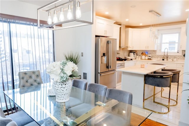 kitchen with sink, white cabinets, pendant lighting, and high end refrigerator