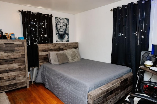 bedroom featuring radiator heating unit and dark hardwood / wood-style flooring