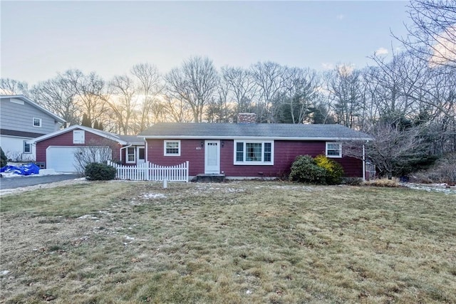 single story home with a garage, a yard, and an outbuilding