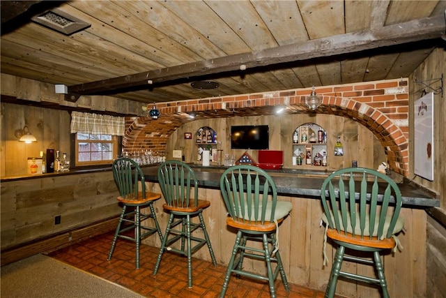 bar with beamed ceiling and wooden walls