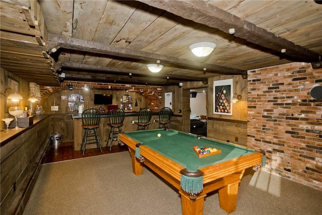 playroom with dark colored carpet, wooden walls, beamed ceiling, and bar area