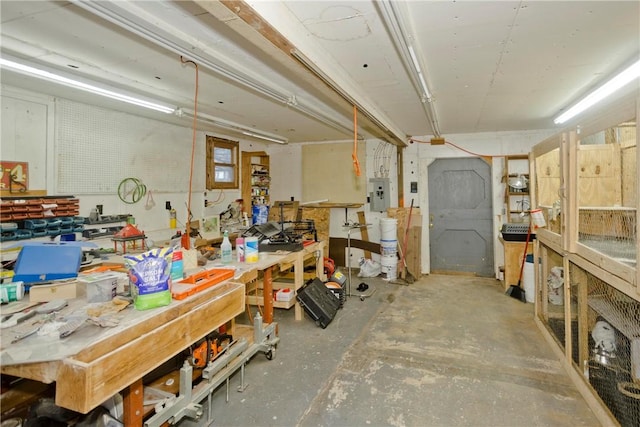 interior space featuring a workshop area, electric panel, and concrete flooring