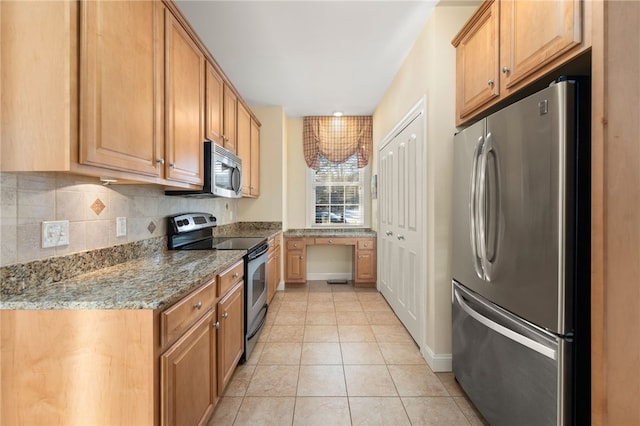 kitchen with light stone counters, tasteful backsplash, light tile patterned floors, and appliances with stainless steel finishes