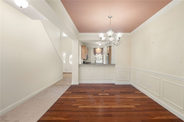 unfurnished dining area with a notable chandelier, dark carpet, and crown molding