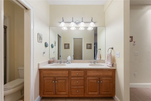 bathroom with toilet, vanity, and tile patterned flooring