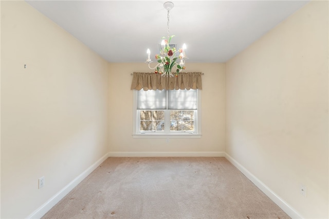 empty room with light carpet and a notable chandelier