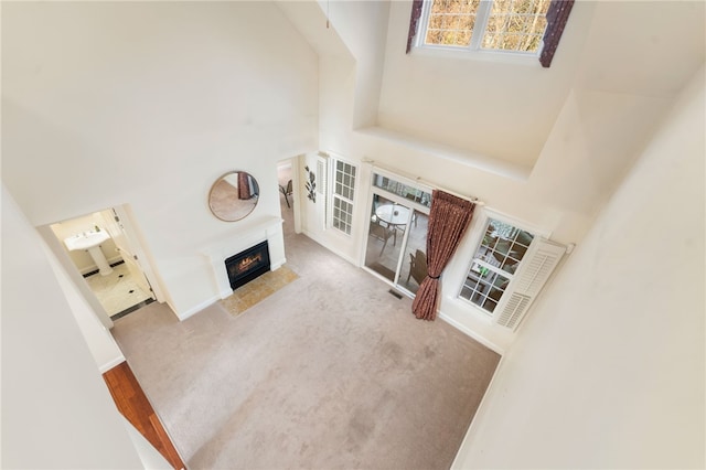 living room with carpet and a towering ceiling