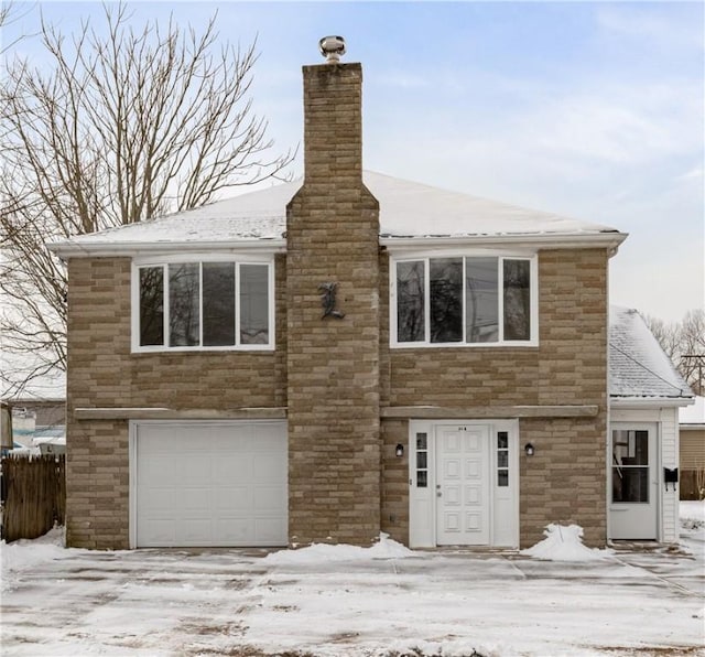 view of front facade featuring stone siding, a chimney, and an attached garage