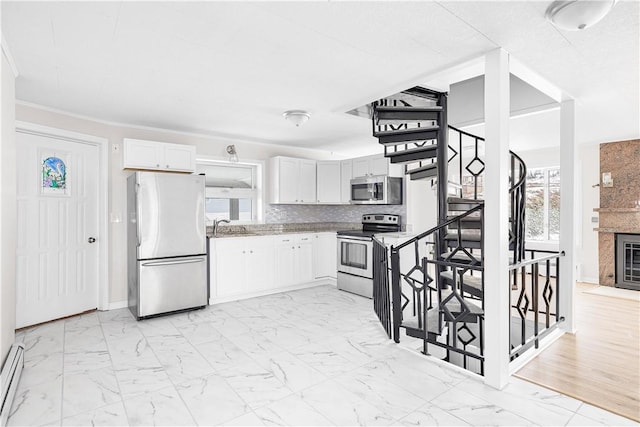 kitchen featuring appliances with stainless steel finishes, marble finish floor, white cabinets, and tasteful backsplash