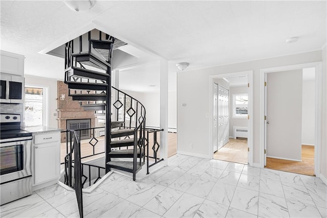 staircase featuring a wealth of natural light, marble finish floor, and baseboards