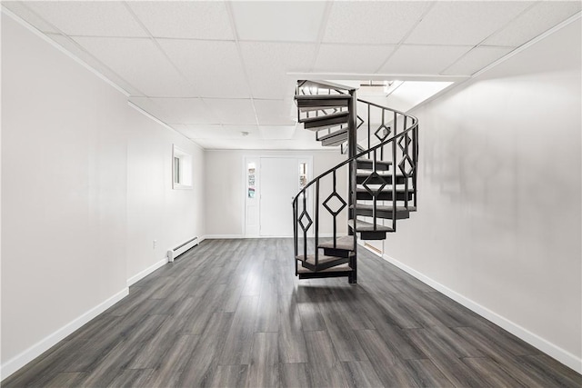 interior space featuring a baseboard radiator, wood finished floors, a paneled ceiling, and baseboards