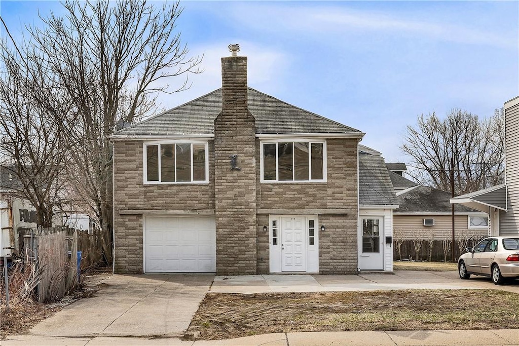 view of front of house with an attached garage, a chimney, driveway, and fence
