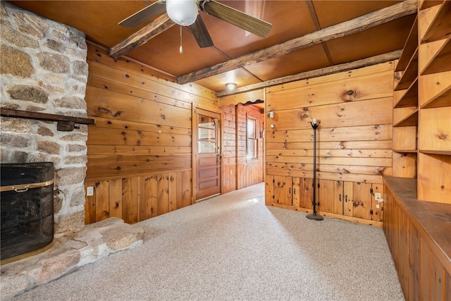 interior space featuring wooden walls, beam ceiling, carpet, and wood ceiling