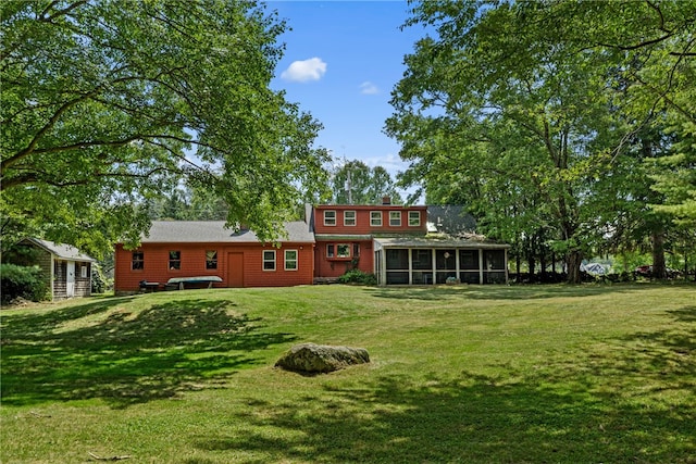 rear view of property with a jacuzzi, a sunroom, and a yard