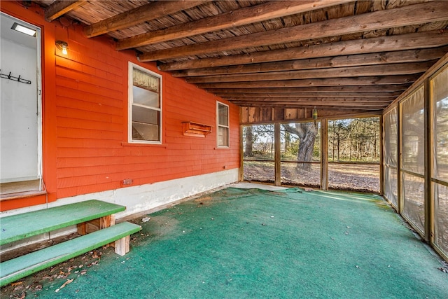 unfurnished sunroom featuring wooden ceiling and vaulted ceiling with beams